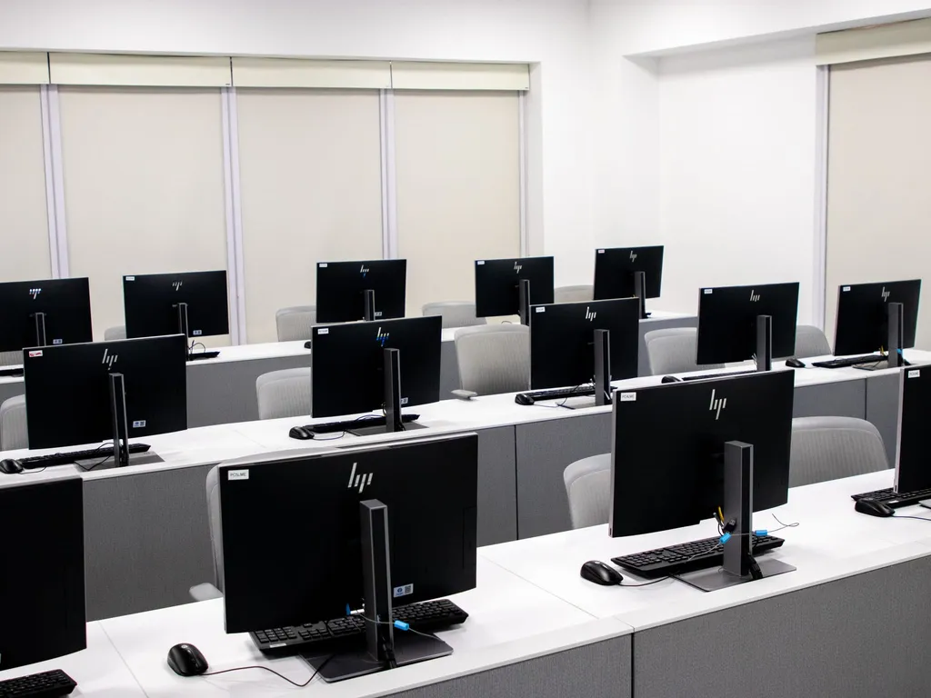 Rows of identical desktop workstations in a computer lab